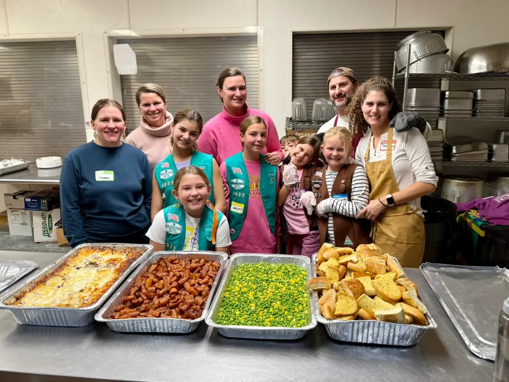 A volunteer group serving a meal they cooked in our kitchen