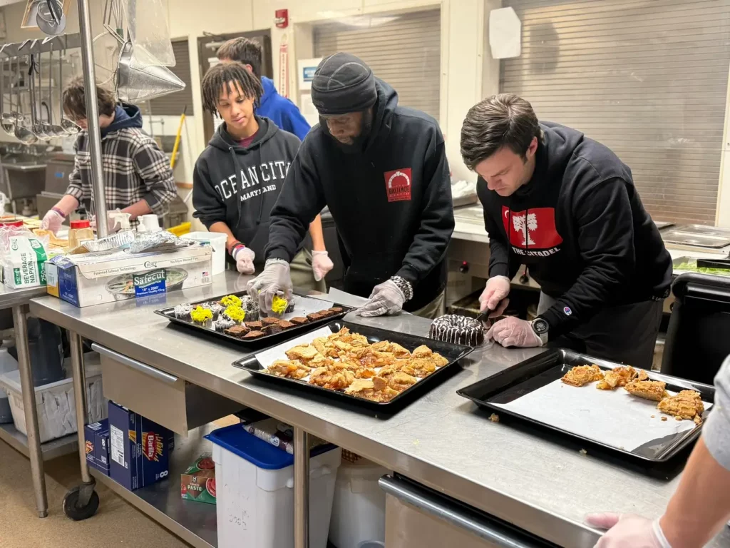 Volunteers plating a meal in the kitchen