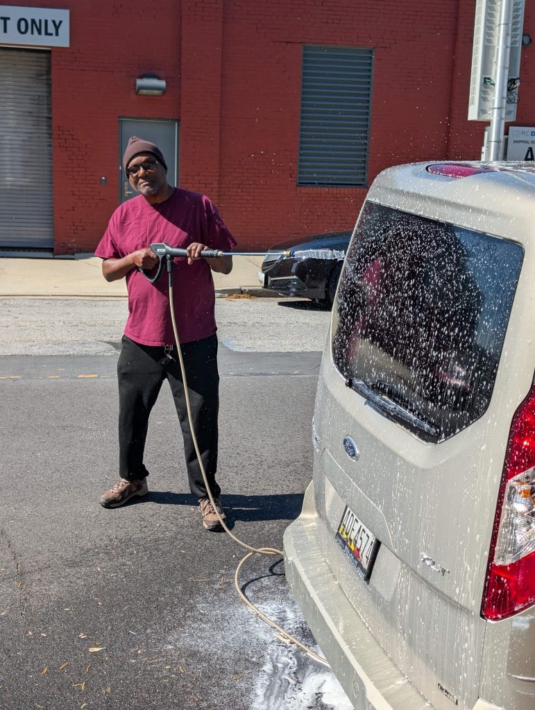 Volunteers and residents power-washing the outreach van