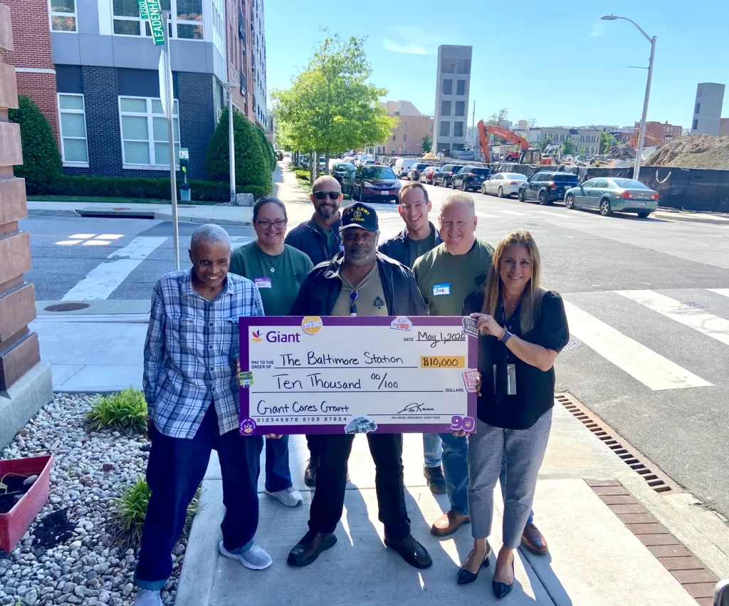 Supporters presenting a donation cheque to The Baltimore Station