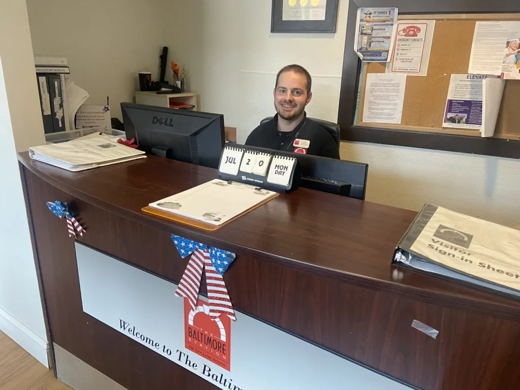 A volunteer staffing the front desk at The Baltimore Station